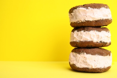 Photo of Sweet delicious ice cream cookie sandwiches on color background, space for text