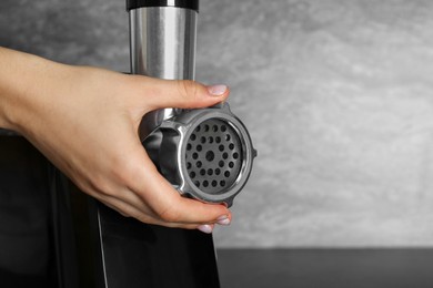 Woman assembling electric meat grinder, closeup. Space for text