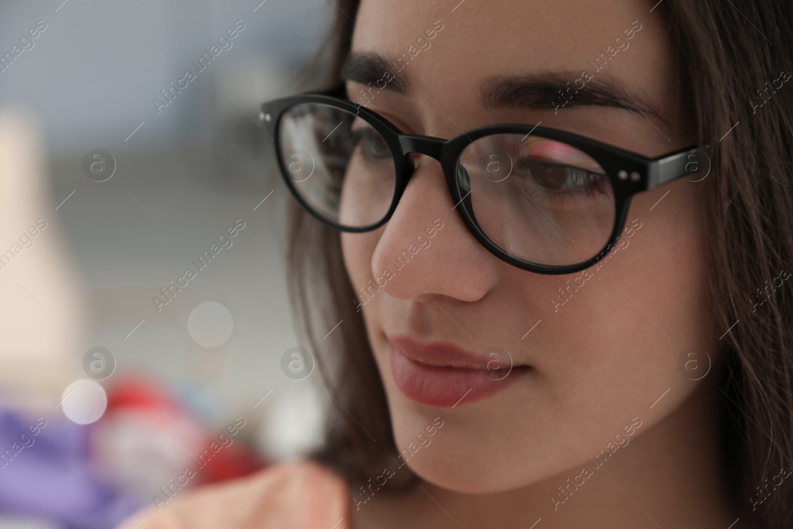 Photo of Beautiful young woman wearing glasses on blurred background. Ophthalmologist service