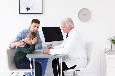 Photo of Young man with his son having appointment at child psychologist office