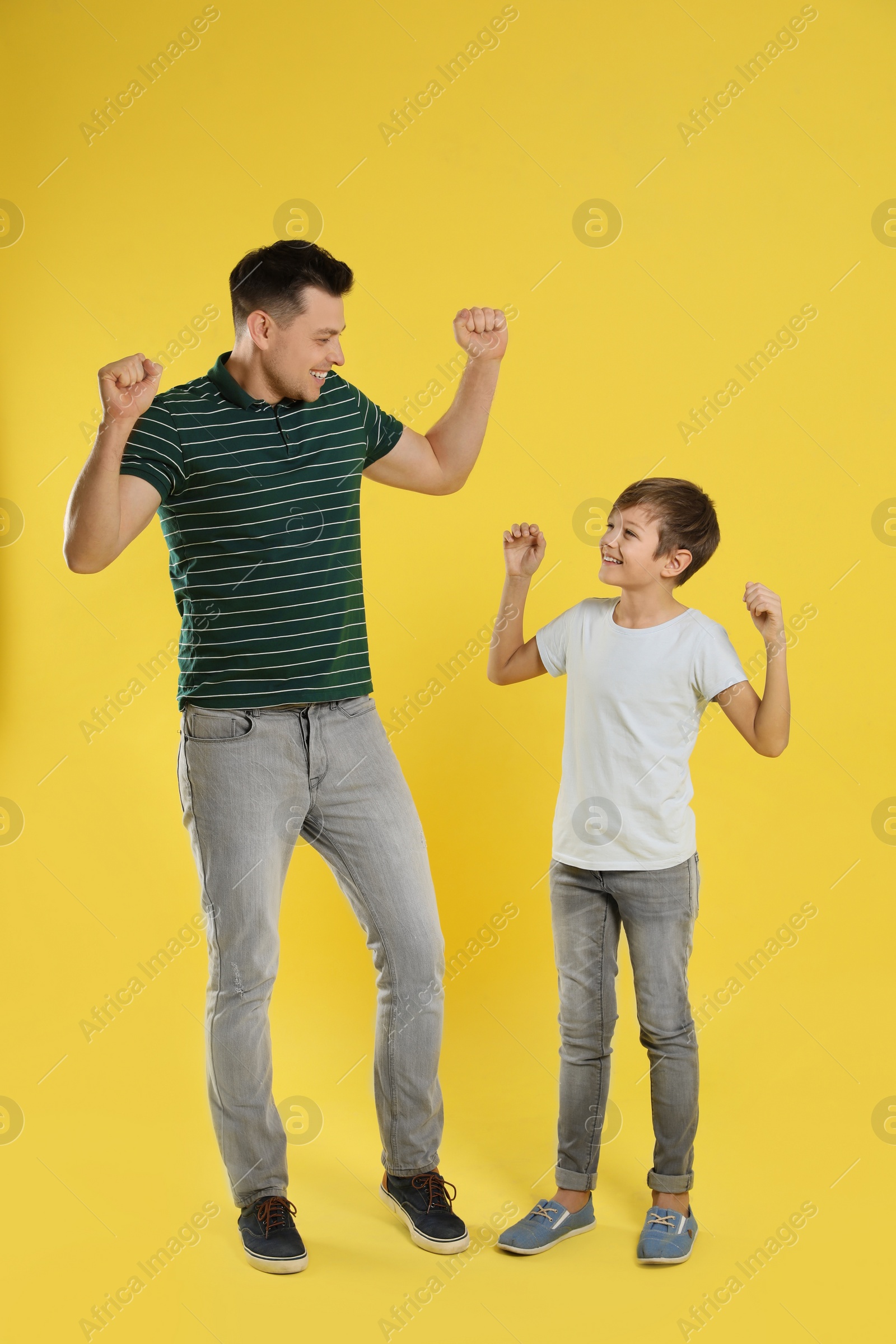 Photo of Portrait of emotional dad and his son on color background