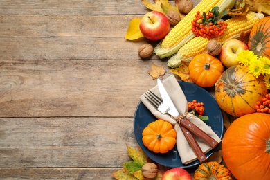Photo of Flat lay composition with tableware, autumn fruits and vegetables on wooden background, space for text. Thanksgiving Day