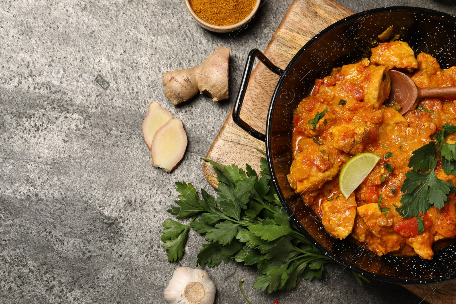 Photo of Delicious chicken curry and ingredients on grey table, flat lay. Space for text