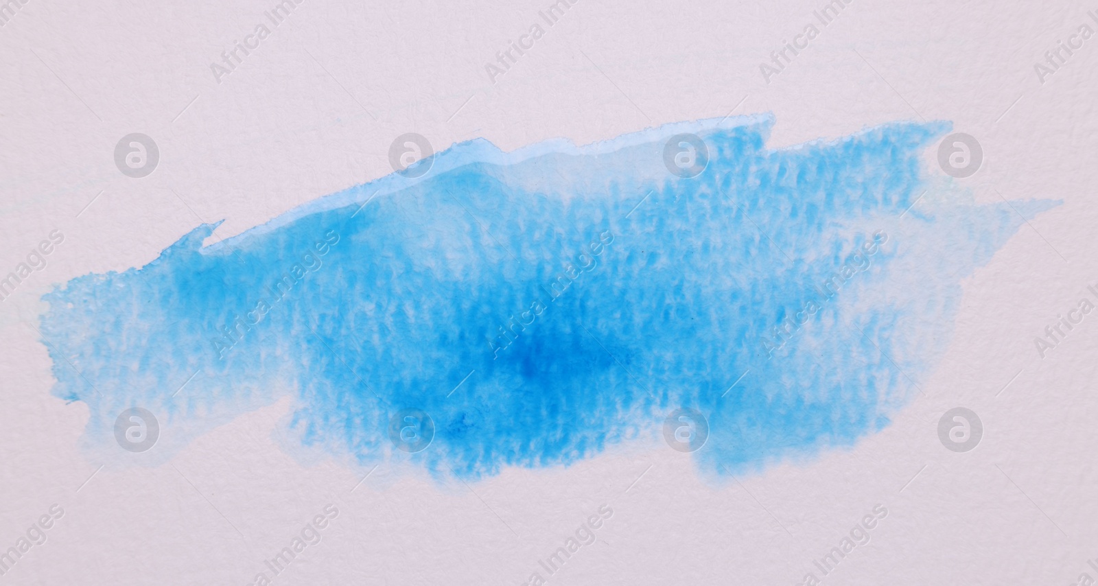 Photo of Blot of blue watercolor paint on white paper, top view