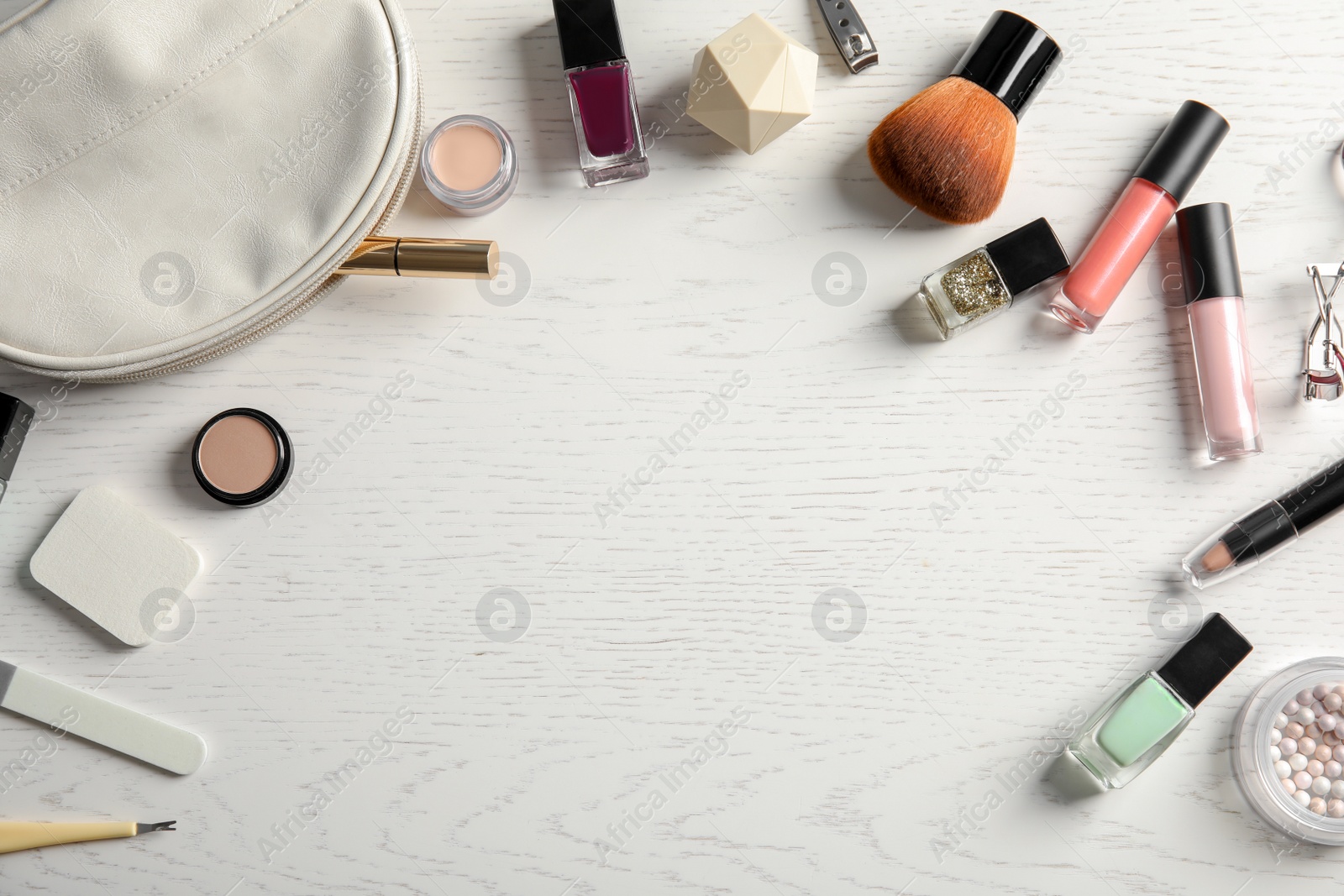 Photo of Flat lay composition with cosmetics, bottles of nail polish and space for text on white wooden background
