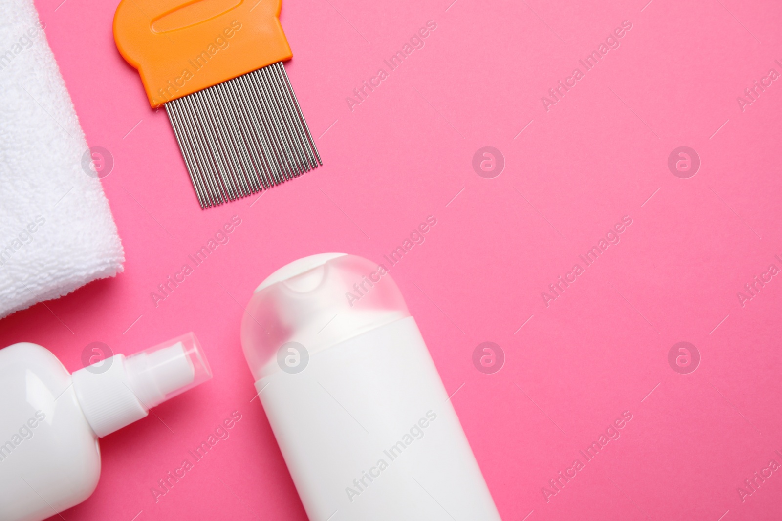 Photo of Products for anti lice treatment, metal comb and towel on pink background, flat lay. Space for text