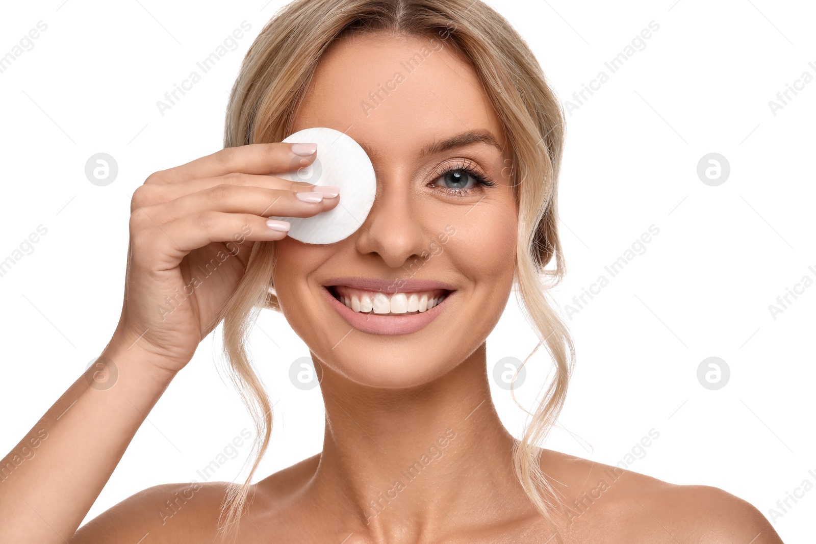 Photo of Smiling woman removing makeup with cotton pad on white background