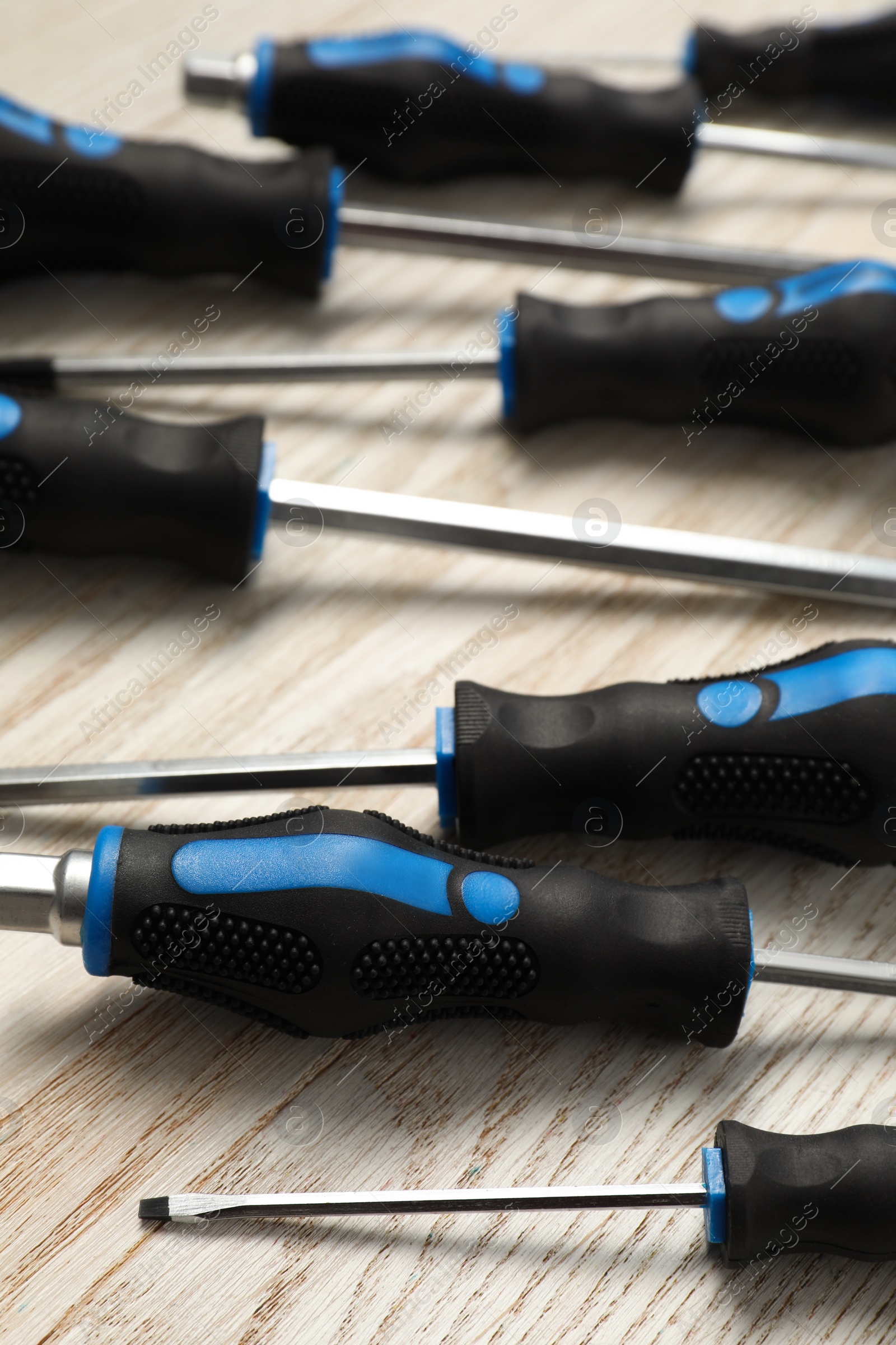 Photo of Set of screwdrivers on white wooden table, closeup