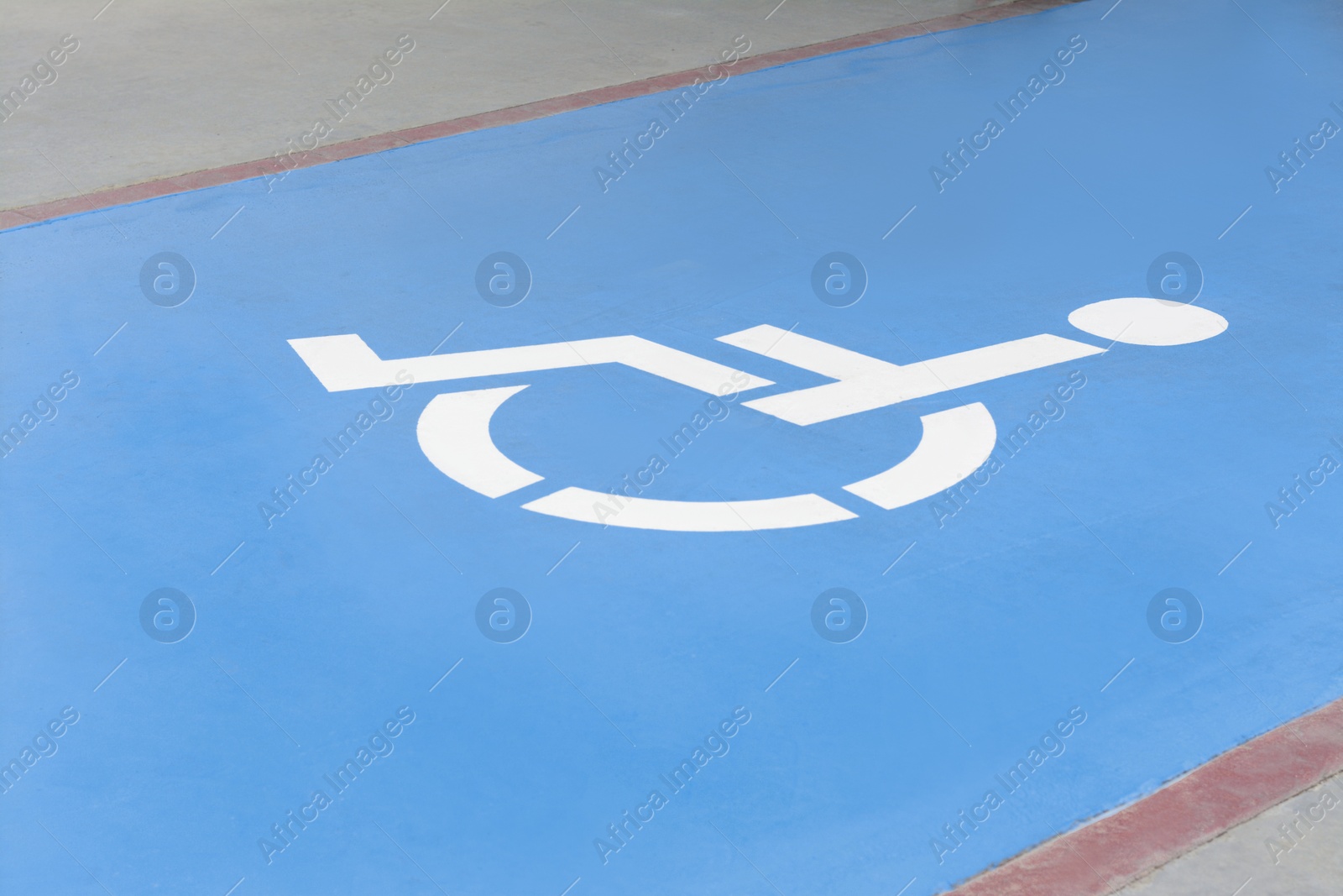 Photo of Wheelchair symbol on asphalt road. Disabled parking permit