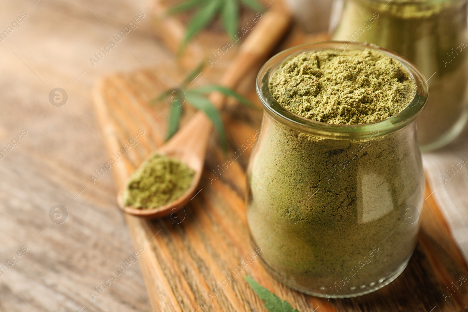 Photo of Jar of hemp protein powder on wooden table. Space for text