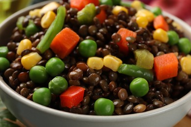 Photo of Delicious lentils with vegetables in bowl, closeup