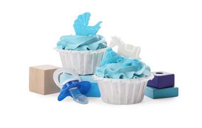 Photo of Baby shower cupcakes with light blue cream near wooden toy blocks and pacifier on white background