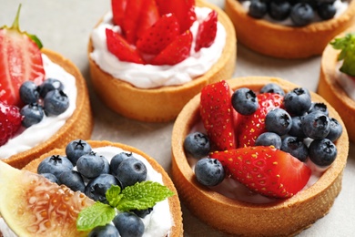 Photo of Delicious sweet pastries with berries on grey table, closeup