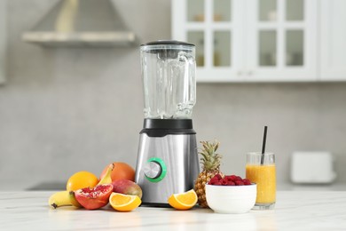 Photo of Tasty smoothie, blender and ingredients on white marble table