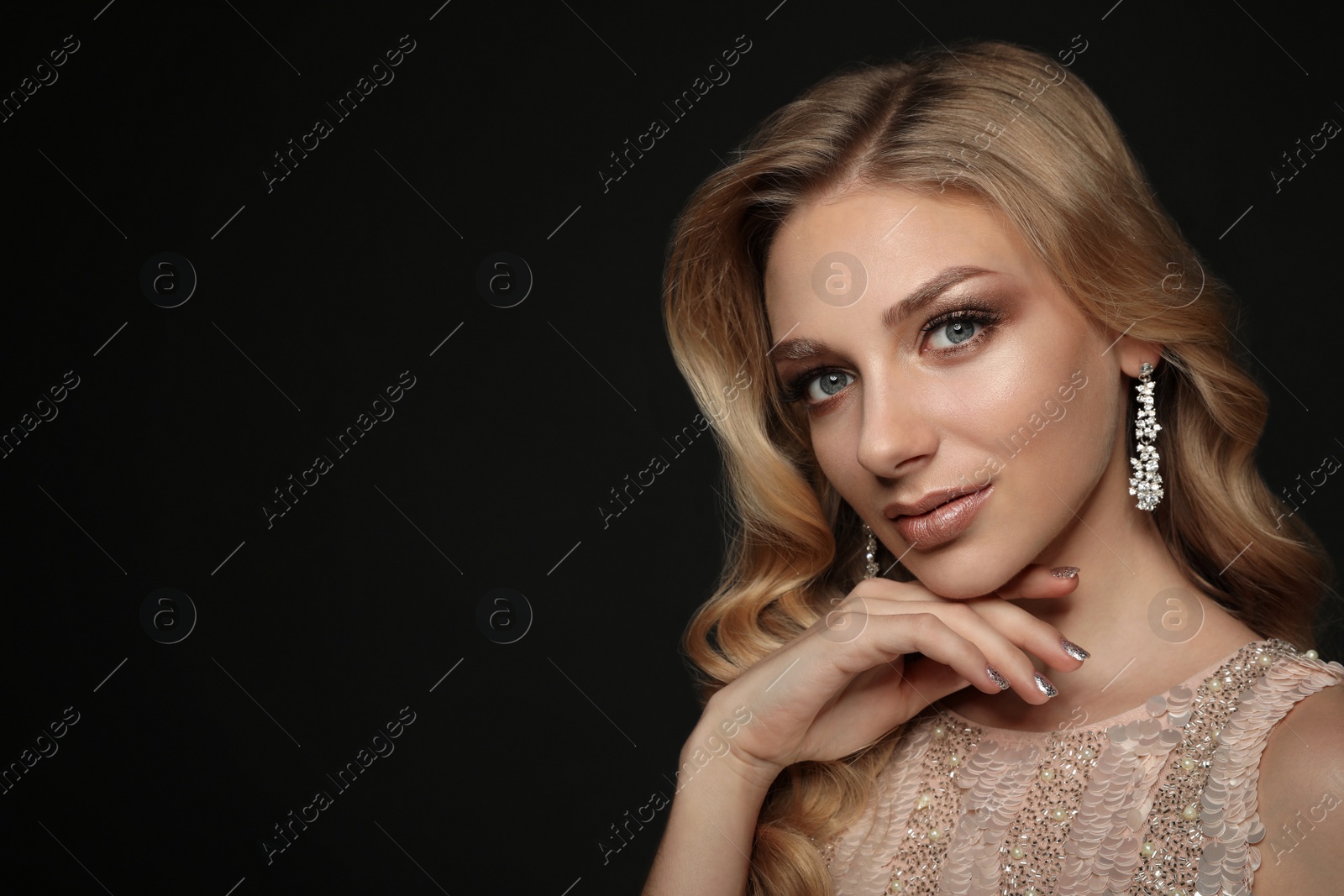 Photo of Beautiful young woman with elegant jewelry on dark background. Space for text