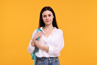 Photo of Cute student with backpack on yellow background
