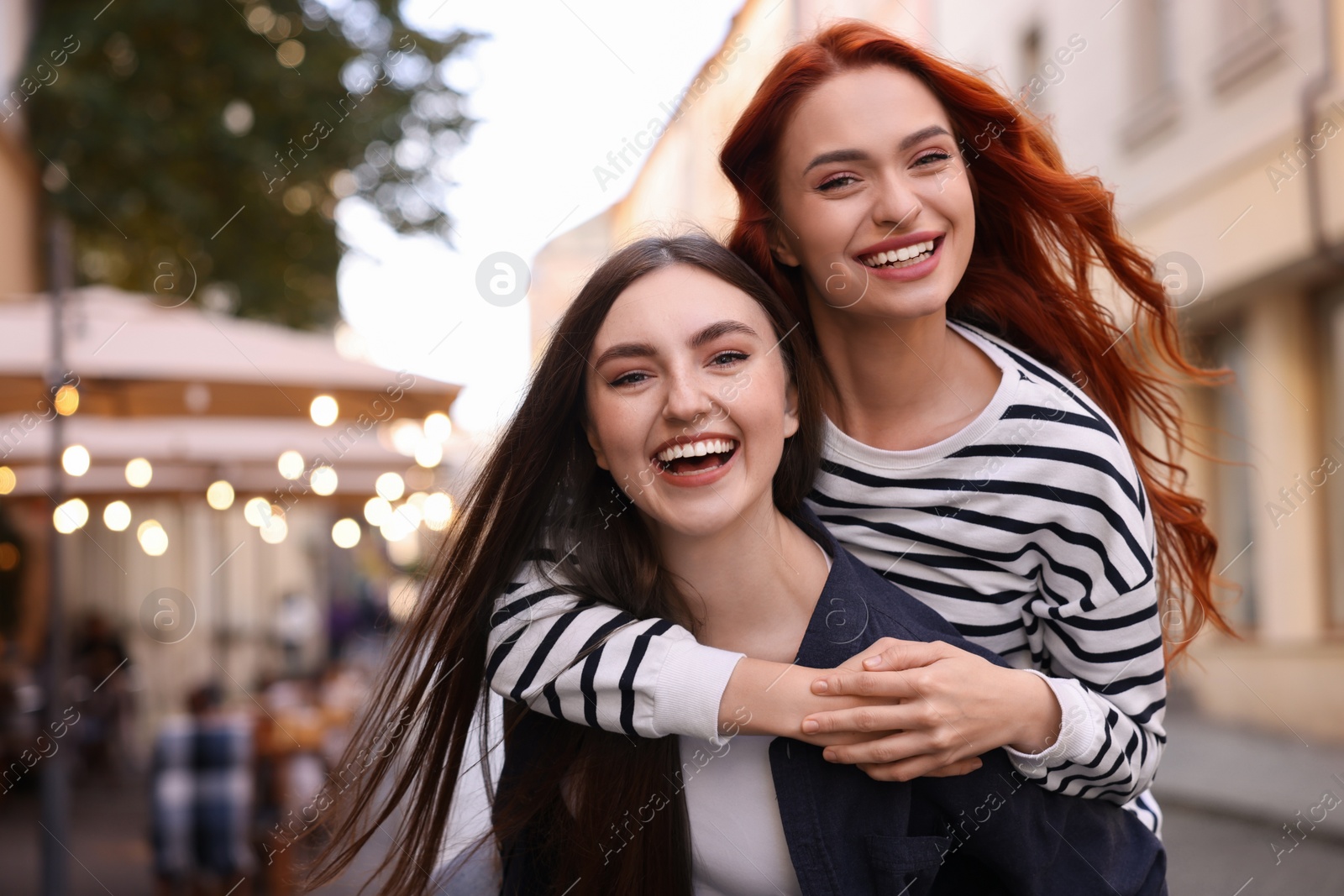 Photo of Happy friends spending time together on city street. Space for text