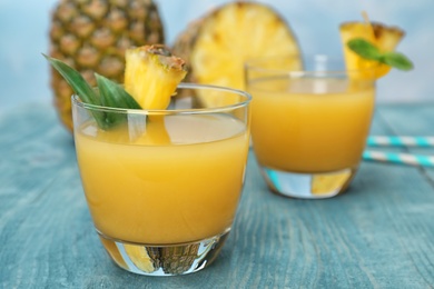 Photo of Glasses with delicious pineapple juice on table