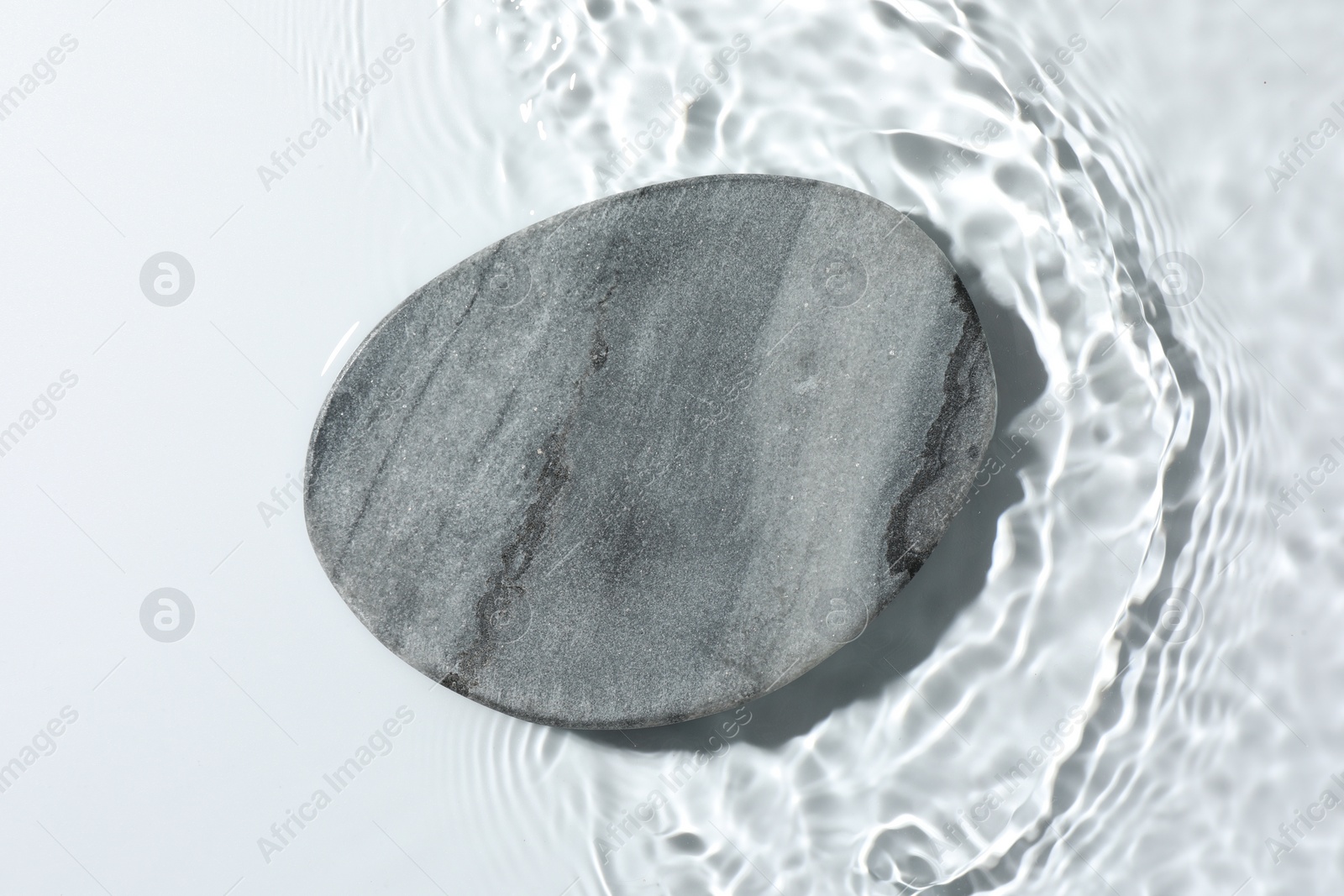 Photo of Presentation for product. Stone podium in water on white background, top view