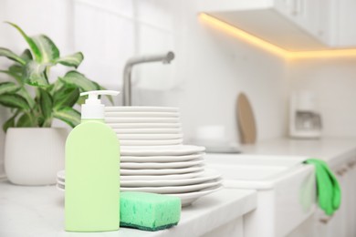 Photo of Clean dishes and cleaning product in stylish kitchen