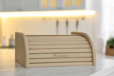 Wooden bread box on white table in kitchen, closeup