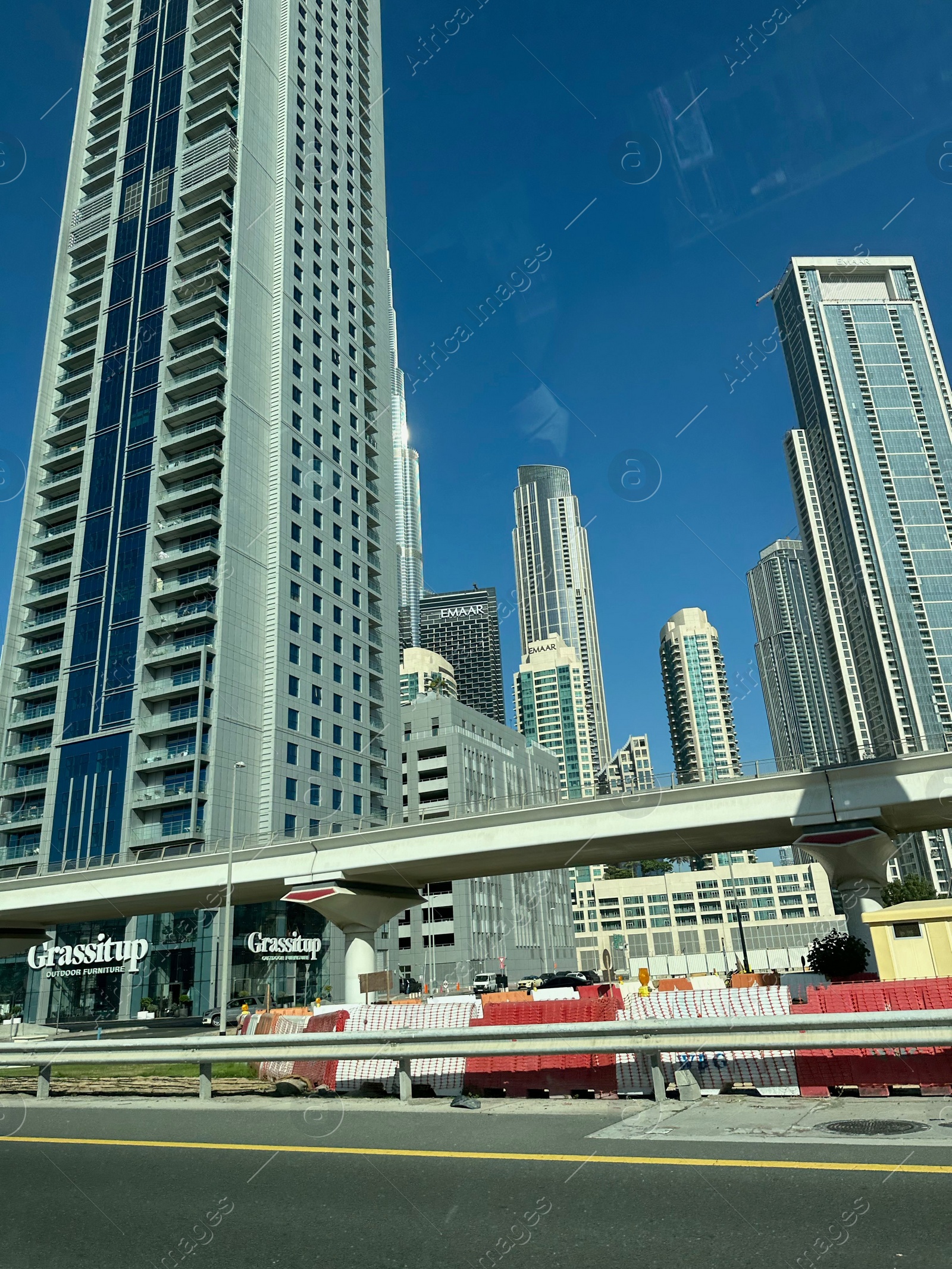 Photo of Dubai, United Arab Emirates - May 2, 2023: Beautiful view of Burj Khalifa and buildings in city under blue sky