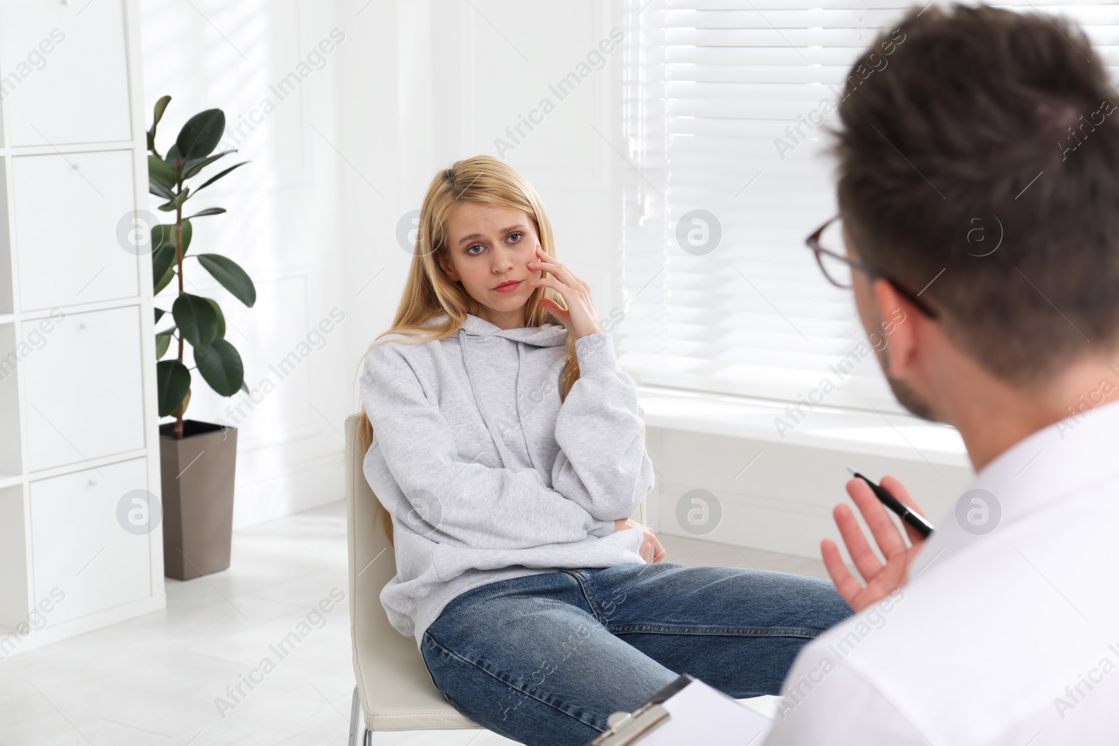 Photo of Psychotherapist working with drug addicted young woman indoors