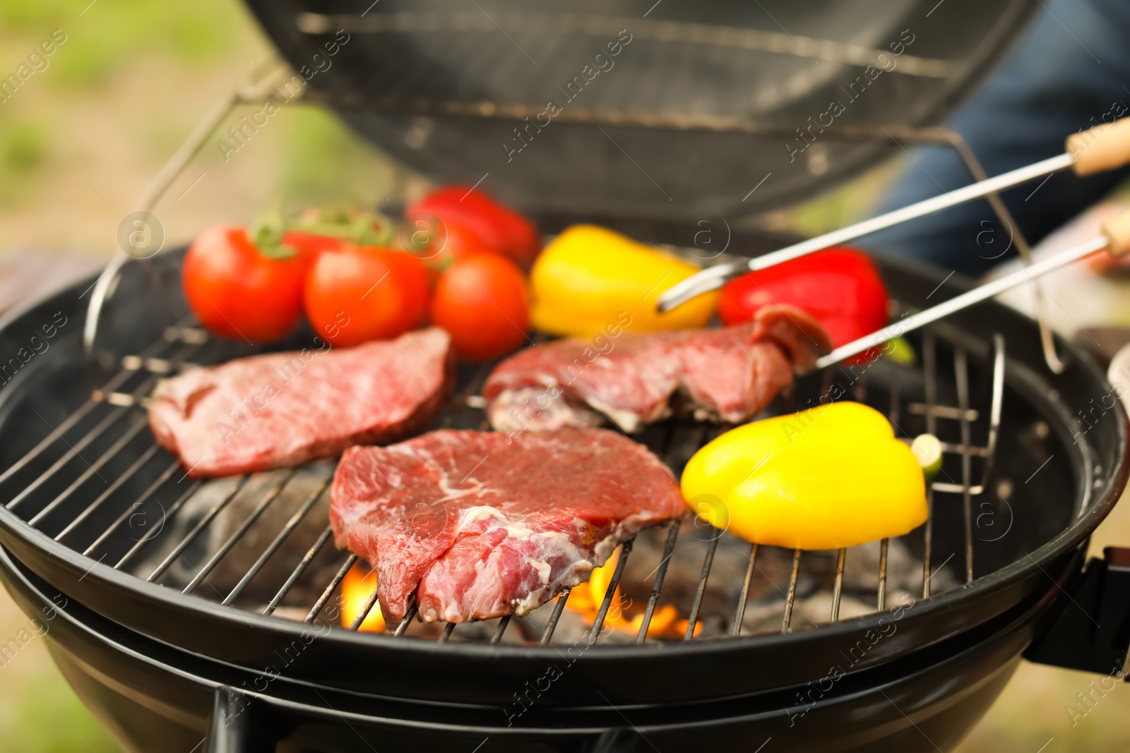 Photo of Modern grill with meat and vegetables outdoors, closeup