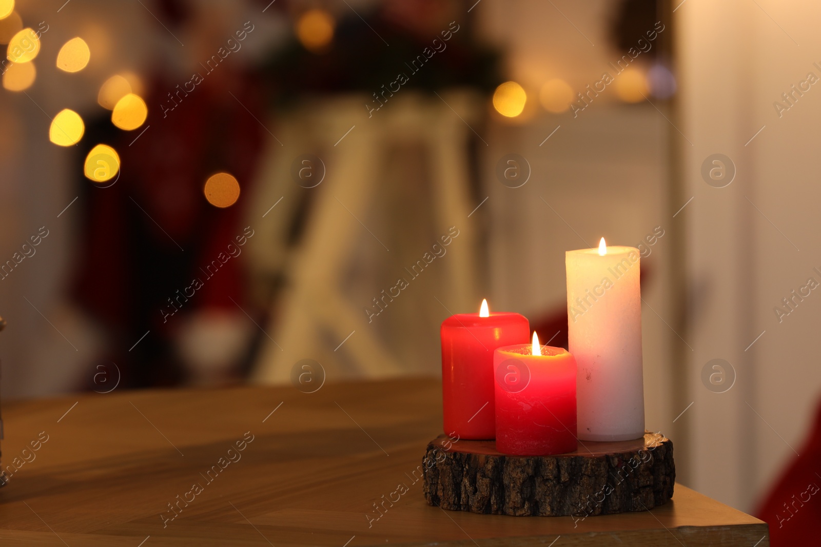 Photo of Beautiful burning candles on table indoors, space for text. Cozy atmosphere