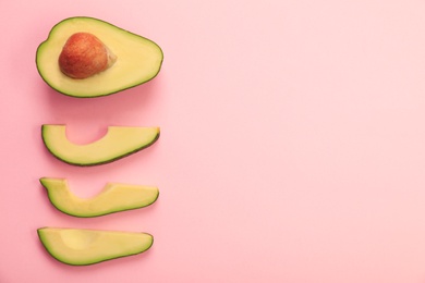 Photo of Flat lay composition with avocado slices on pink background. Space for text