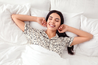 Young woman in bed at home, top view. Lazy morning