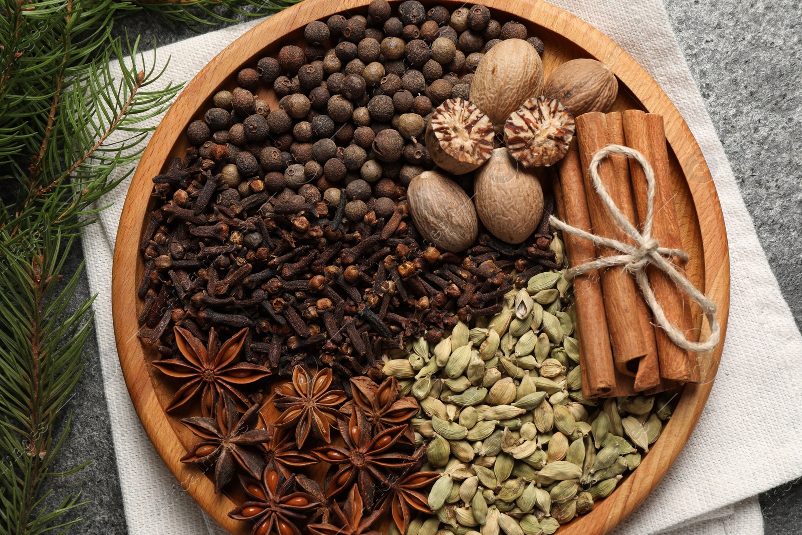 Photo of Different spices, nuts and fir branches on table, flat lay