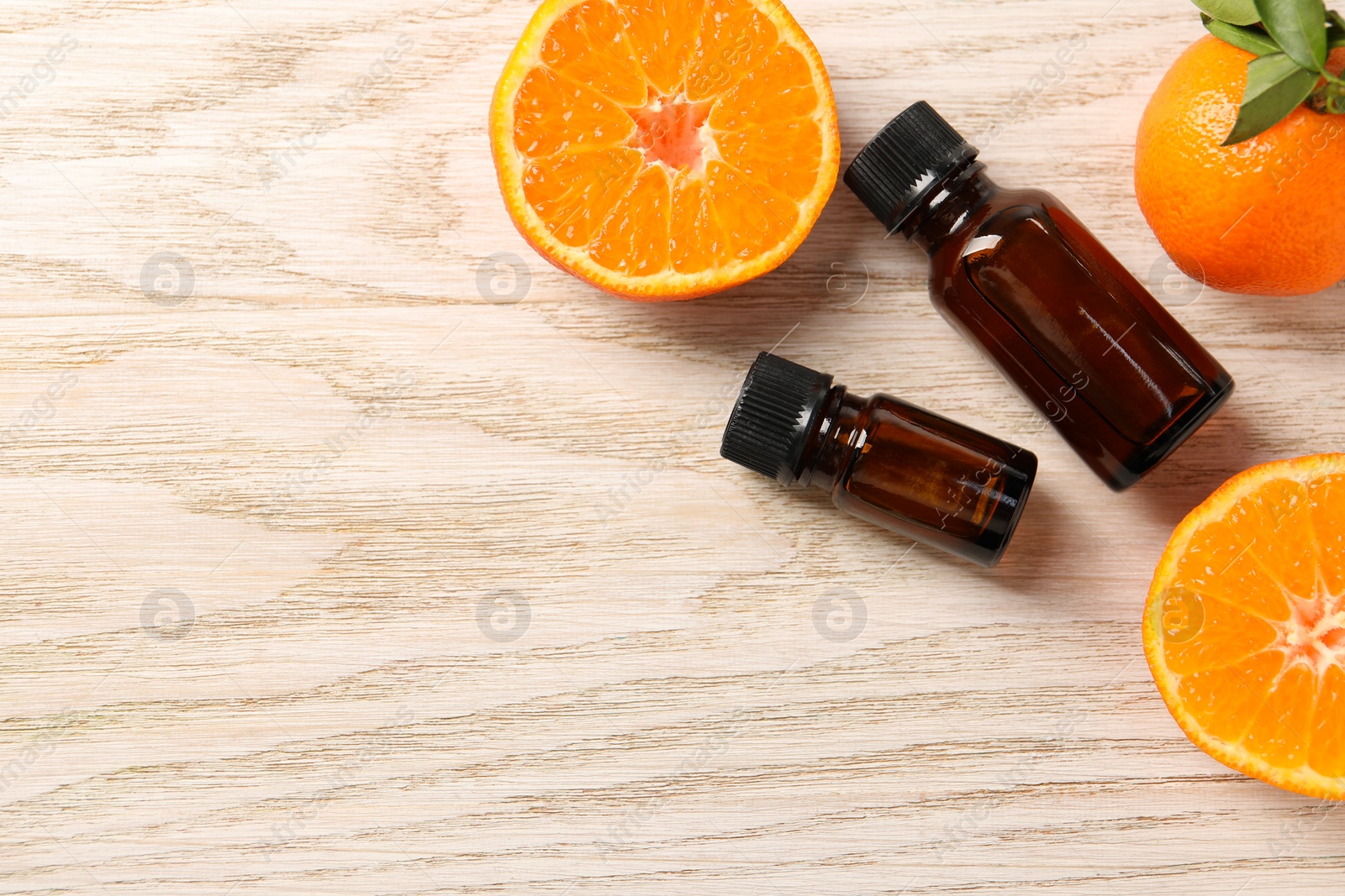 Photo of Flat lay composition with tangerine essential oil on wooden table. Space for text