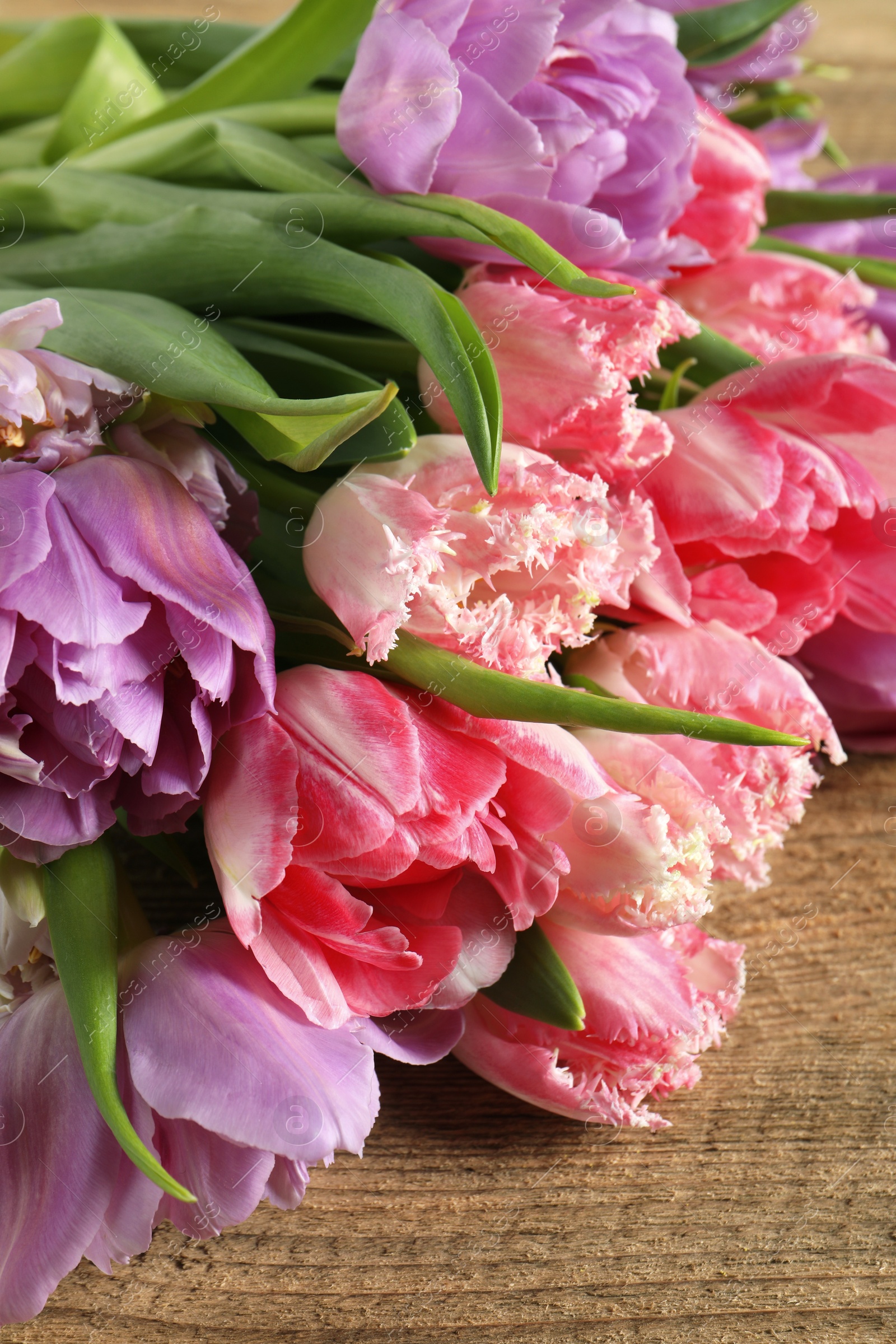 Photo of Beautiful bouquet of colorful tulip flowers on table, closeup