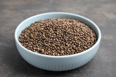 Photo of Bowl with hemp seeds on grey table