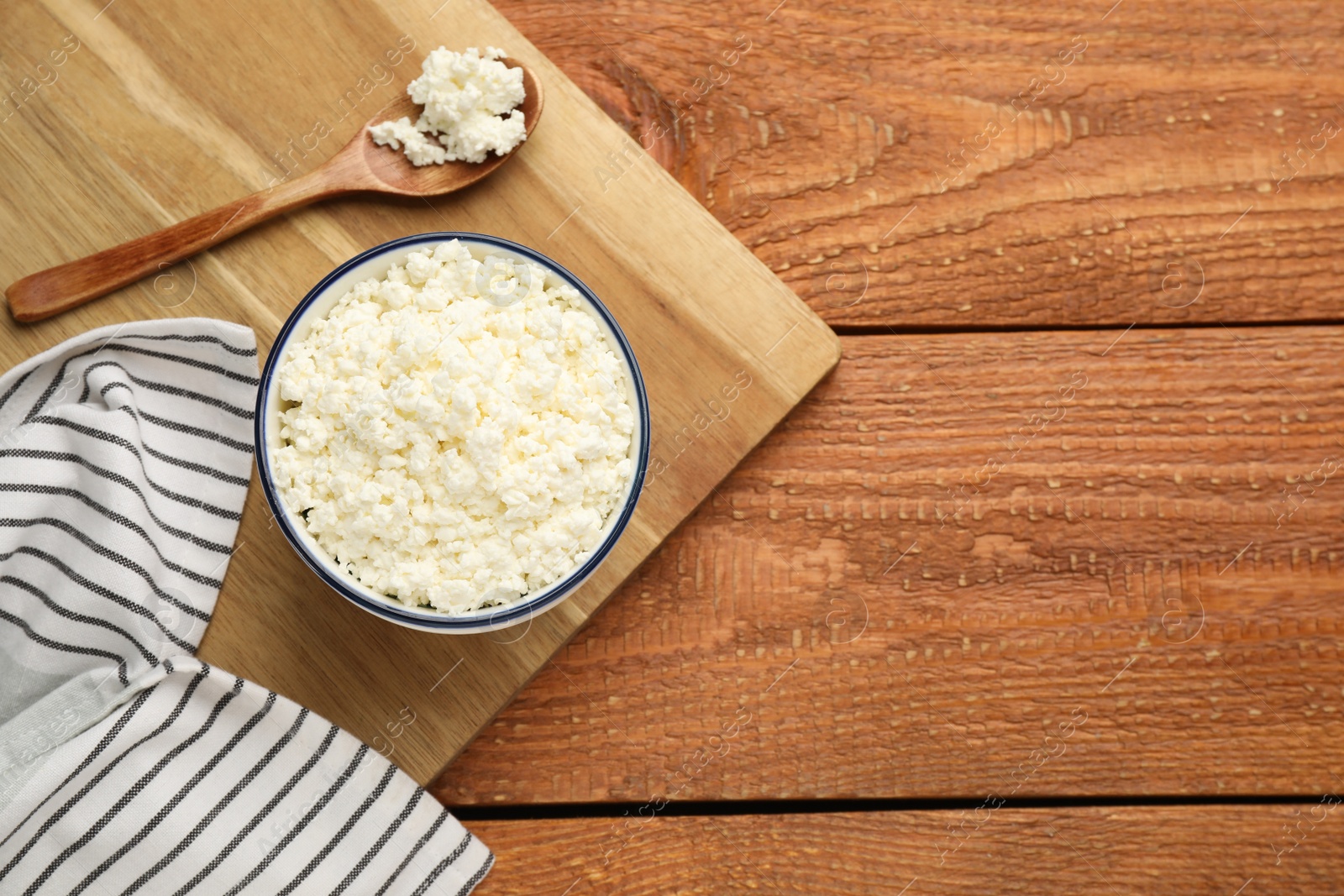 Photo of Delicious fresh cottage cheese on wooden table, top view. Space for text