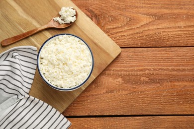 Photo of Delicious fresh cottage cheese on wooden table, top view. Space for text