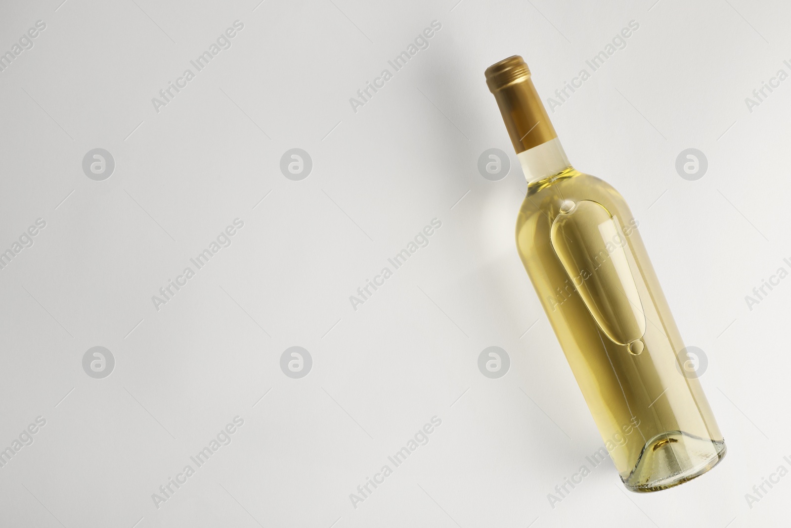Photo of Bottle of expensive white wine on light background, top view. Space for text