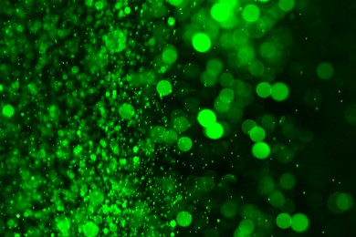 Image of St. Patrick day. Shiny green glitter on black background, bokeh effect