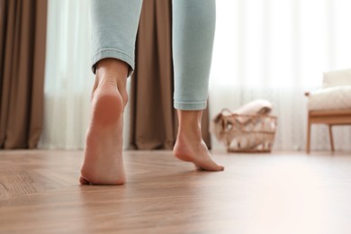 Woman walking barefoot at home, closeup. Floor heating concept