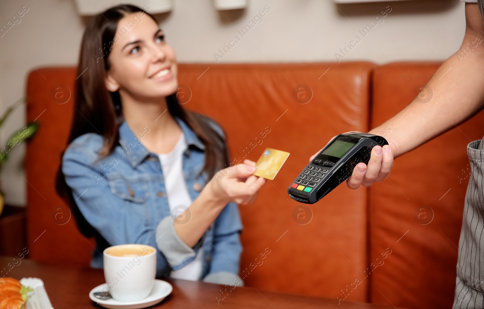 Photo of Woman using terminal for credit card payment in cafe