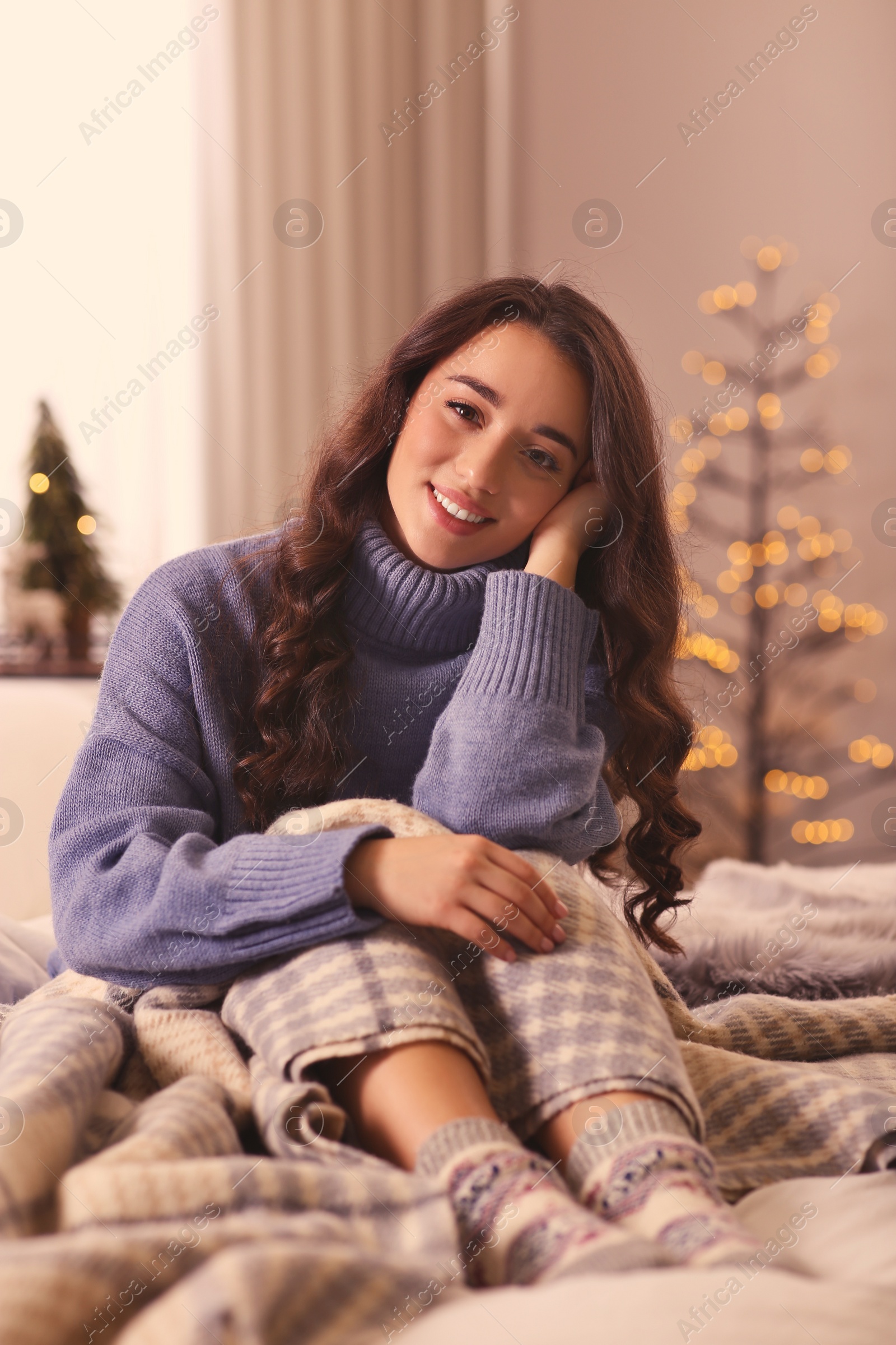 Photo of Young woman in knitted sweater resting at home. Winter atmosphere