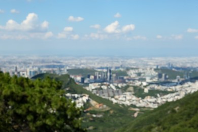 Trees and buildings under beautiful sky in city, blurred view