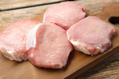 Photo of Pieces of raw pork meat on wooden table, closeup