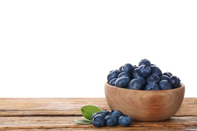 Photo of Bowl with tasty fresh blueberries on wooden table against white background