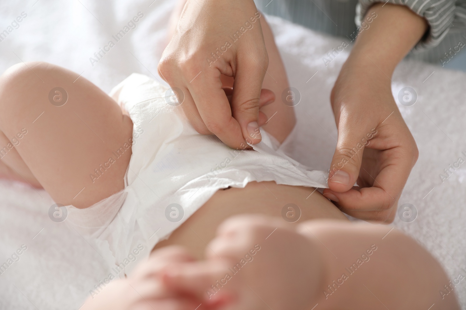 Photo of Mother changing her baby's diaper on table, closeup