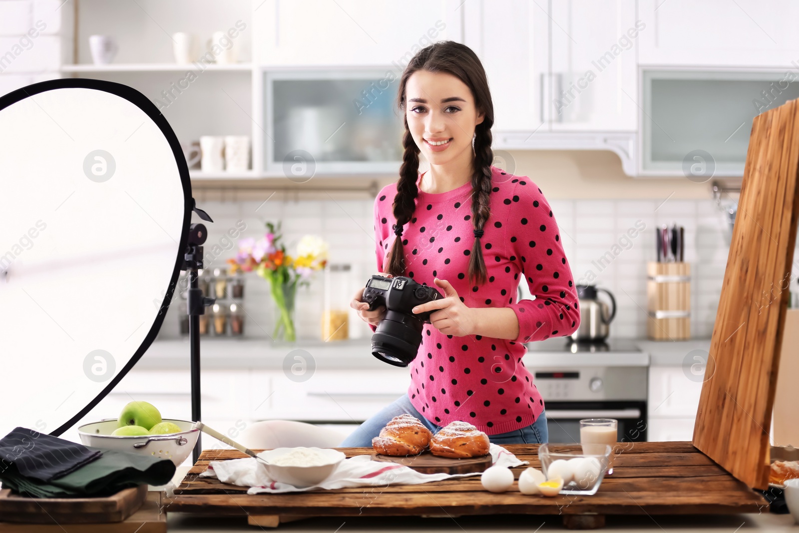 Photo of Young woman with professional camera taking food photo in studio