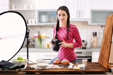 Photo of Young woman with professional camera taking food photo in studio