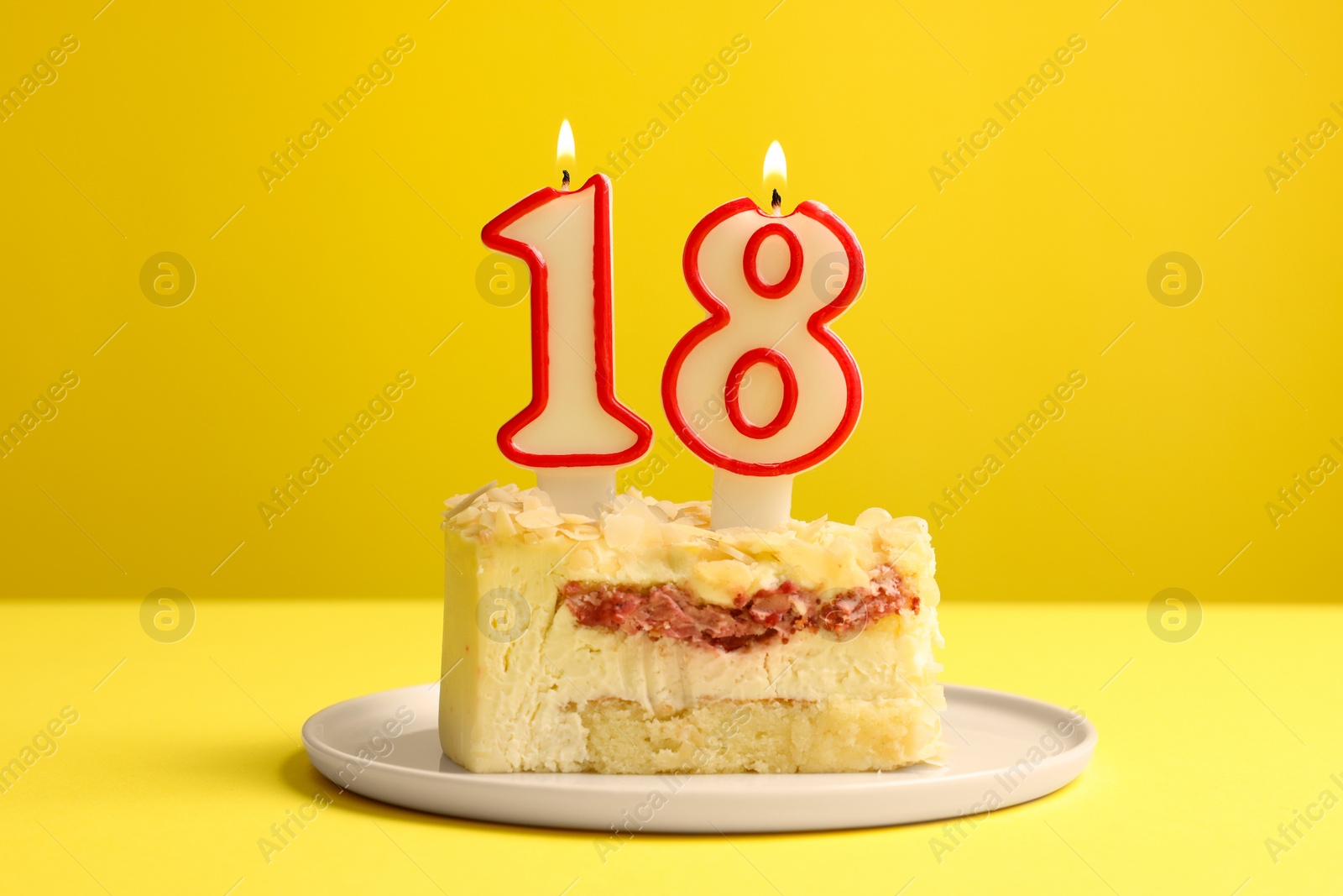 Photo of Coming of age party - 18th birthday. Delicious cake with number shaped candles on yellow background