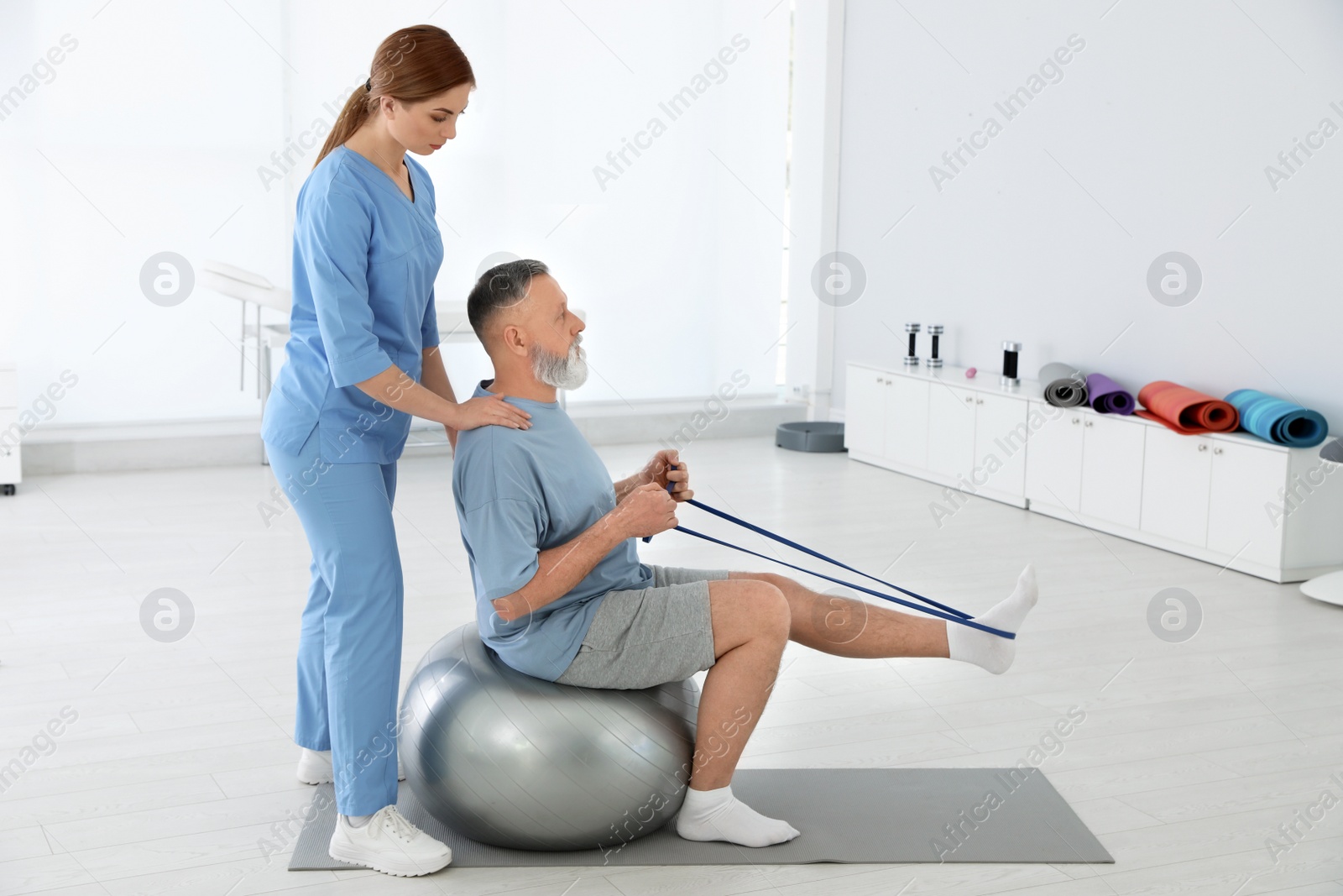 Photo of Professional physiotherapist working with senior patient in rehabilitation center